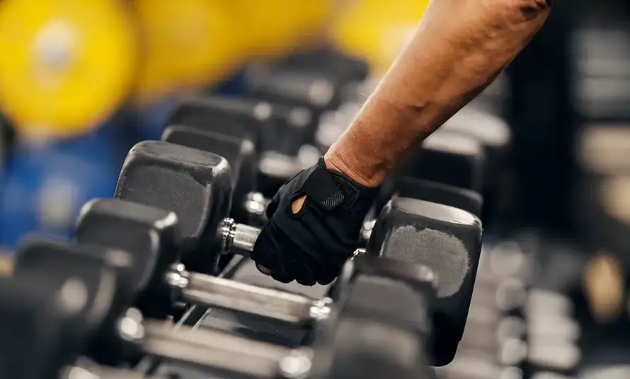 A confident, athletic man standing outdoors at sunrise, stretching or lifting his hands with strength and focus.